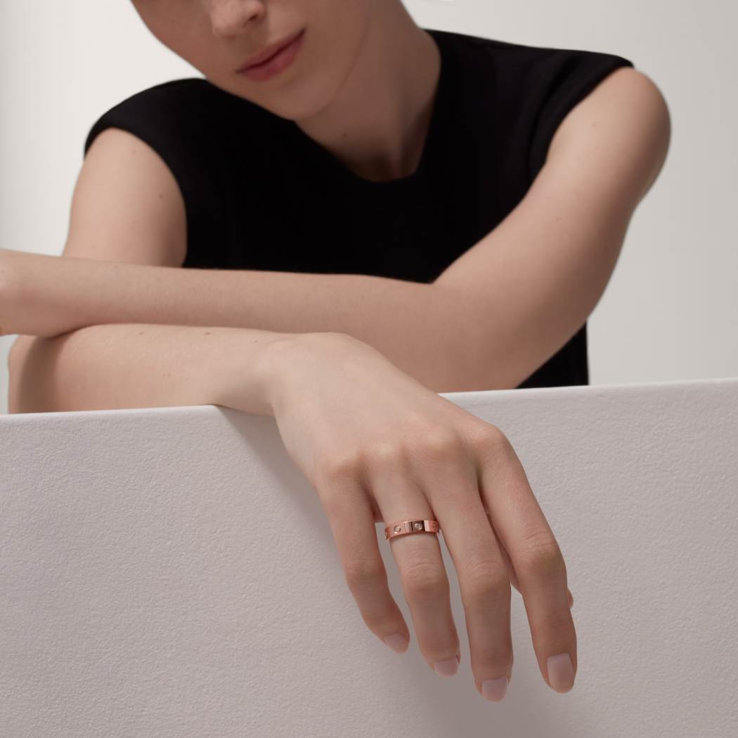 Cartier classic 18K rose gold LOVE ring adorned with eight diamonds